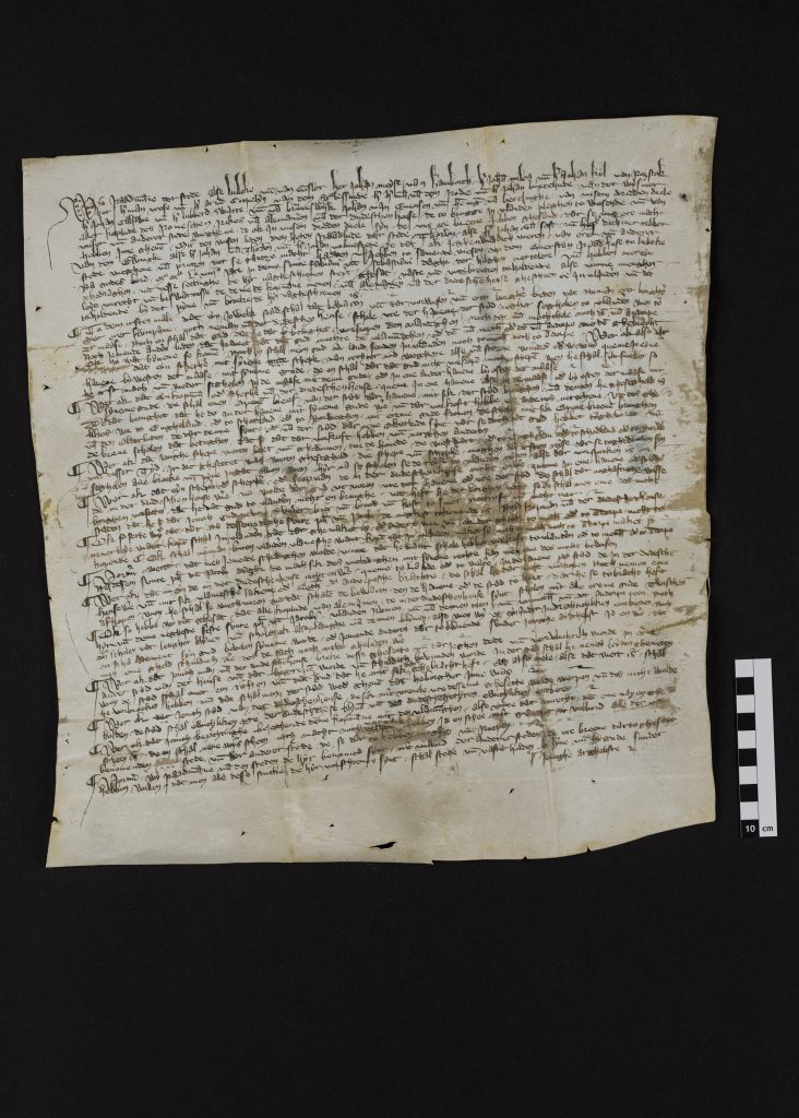 Fotografie eines Faksimiles eines mittelalterlichen Schriftstücks, das einen Aufruf zum Boykott Flanderns aus dem Jahr 1358 enthält.